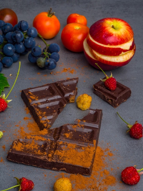 Anticancer food good for cardiovasculas system fresh ripe grape dark chocolate raspberries tomatoes apple on concrete background Food rich in resveratrol antioxidants