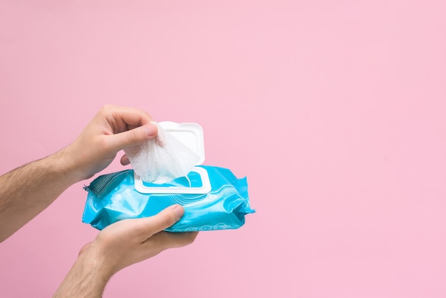 Antimicrobial napkin for hand disinfection during a coronavirus pandemic on pink background. space for text .