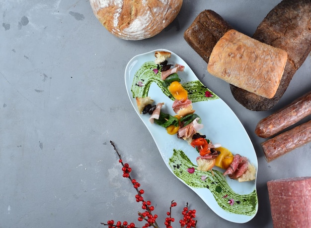 Antipasti Italian dish. Appetizer of meat, vegetables and herbs on a gray table