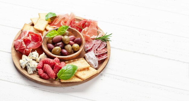 Photo antipasto board with prosciutto salami crackers cheese olives