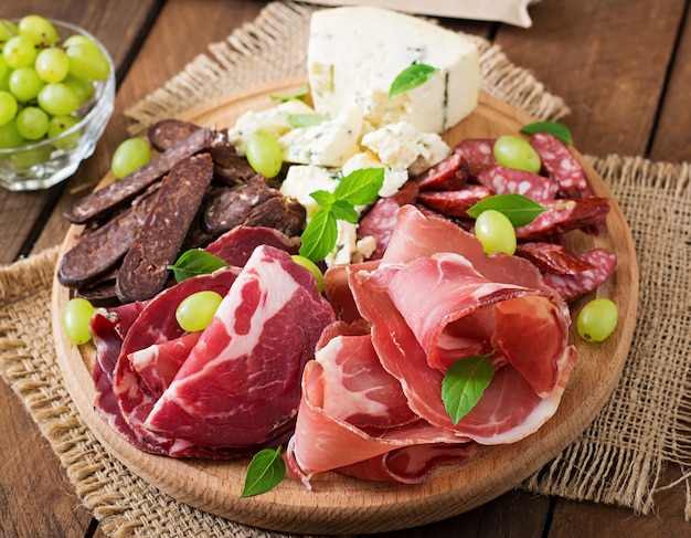 Antipasto catering platter with bacon, jerky, sausage, blue cheese and grapes 