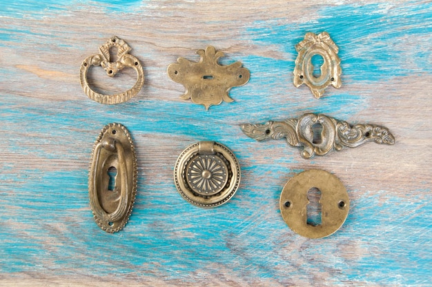 Antique brass key hole covers on wooden background. Copy space for text.