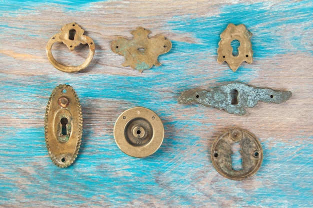 Antique brass key hole covers on wooden background. Copy space for text.