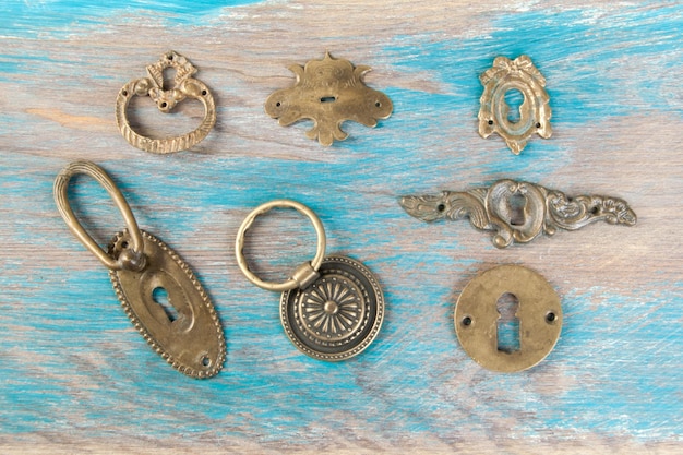 Antique brass key hole covers on wooden background. Copy space for text.