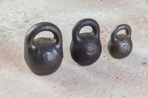 Photo antique iron weights for scales on a concrete table