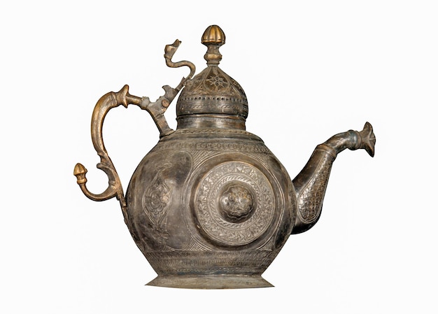 An antique metal teapot with artistic chasing and engraving on a white background