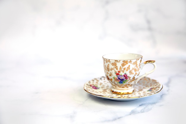 Antique porcelain tea cup on white background copy space traditional english vintage ceramics