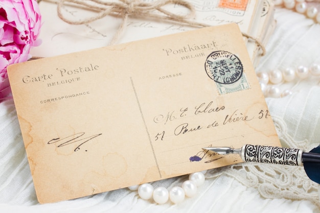 Antique postcard with feather pen and pearl jewelery