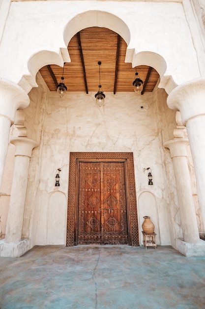 Antique wooden door with architectural arch in an ancient sandstone house in Bur Dubai near Creek area