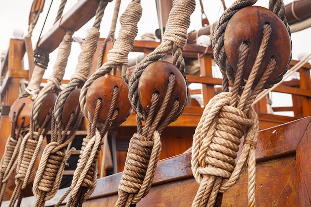 Antique wooden sailing ship with wooden rigging blocks and ropes