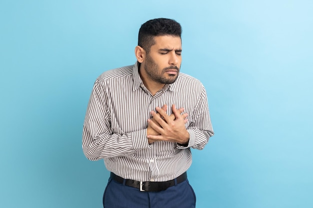 Anxious businessman holding hand on chest feeling awful acute pain in heart risk of heart attack