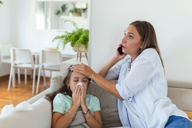 Anxious young mom call ambulance doctor take care of sick small girl child having flu and high temperature. Worried mother contact therapist or pediatrician with little daughter feel ill.