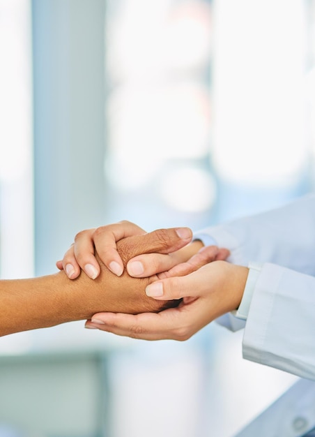 Any challenge is one well face together Closeup shot of an unrecognizable doctor holding a patients hand in comfort