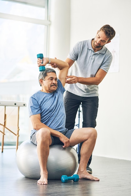 Any discomfort at all Full length shot of a young male physiotherapist assisting a senior patient in recovery