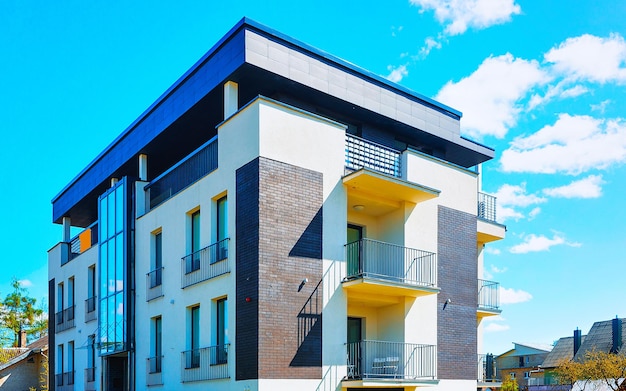 Apartment in residential building exterior. Housing structure at blue modern house of Europe. Rental home in city district on summer. Wall and glass high architecture for business property investment.