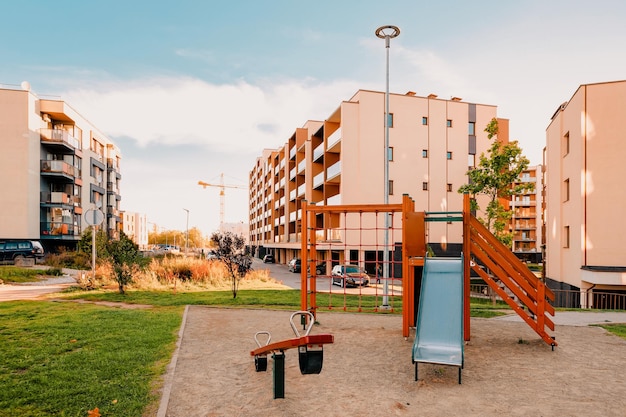 Apartment residential house facade architecture and child playground and outdoor facilities. Blue sky on the background.