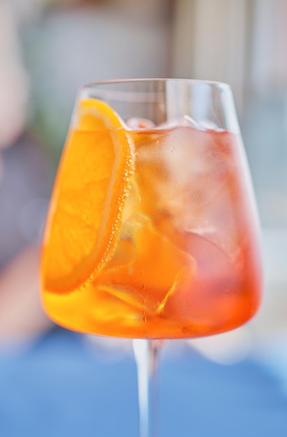 Aperol cocktail closeup selective focus Aperol Spritz is a cocktail consisting of prosecco aperitif and sparkling water Beautiful orange cocktail vertical frame