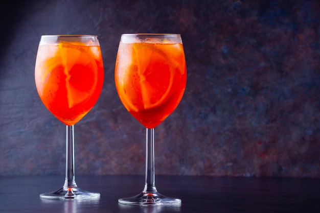 Aperol spritz cocktail in glass on dark background Two glasses of aperol spritz with sliced orange