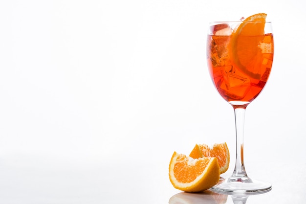 Aperol spritz cocktail in glass on white wall 