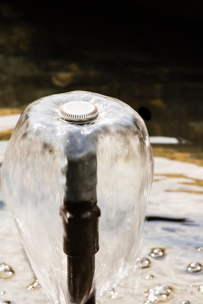 Apex view of metal fountain nozzle with fountain water