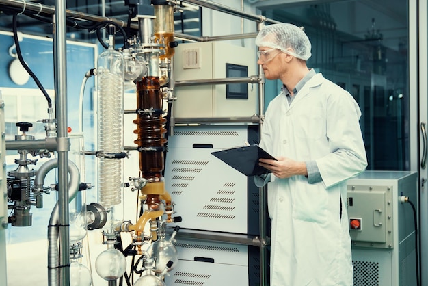 Apothecary scientist recording information from a CBD oil extractor