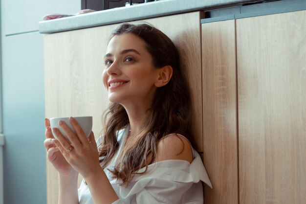 Appealing darkeyed woman drinking coffee in the morning