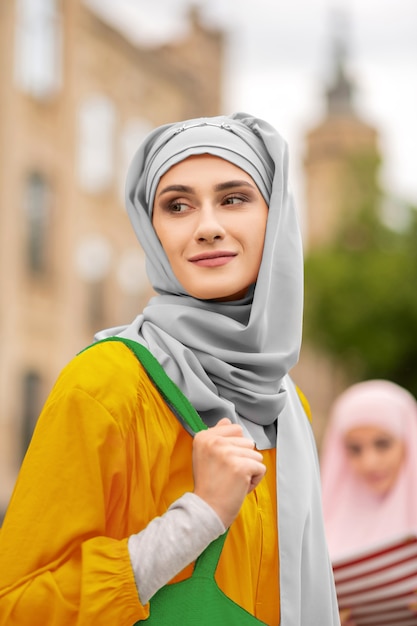 Appealing woman. Appealing young muslim woman wearing nice grey hijab standing outside