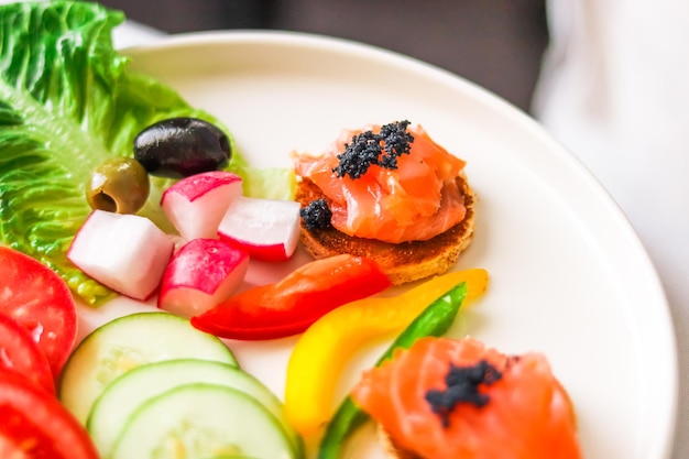 Appetiser platter with salmon black caviar and sliced fresh vegetables for hospitality and gastronomy