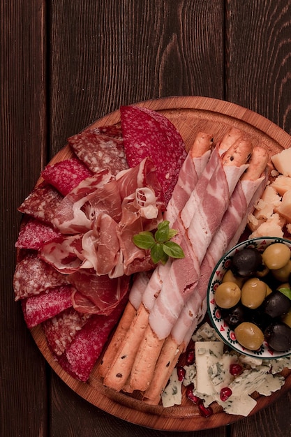 Appetizer assortment set sausage and cheese on a wooden board top view no people