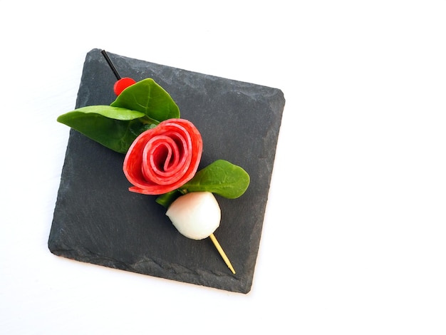 Appetizer canape in the form of a rose flower with leaves