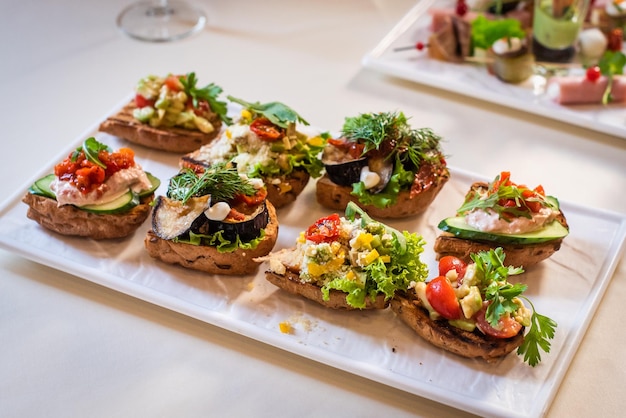 Appetizers at the wedding reception gourmet bruschetta with pate zucchini tomato cucumber and herbs