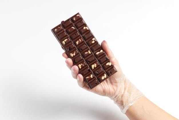 Appetizing bar of chocolate with nut filling in confectioner hand