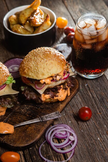 Appetizing burger with chicken cutlet on a wooden board