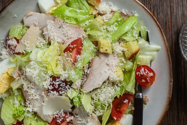 Appetizing Caesar salad in a plate on a wooden table