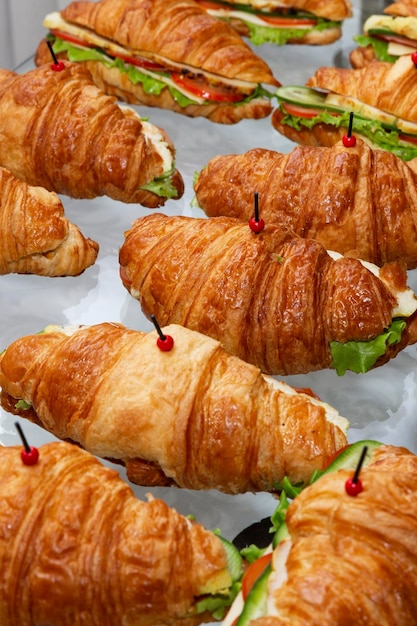 Appetizing croissants sandwiches on the buffet table Business lunches and catering Closeup Vertical