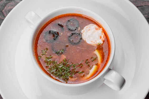 Appetizing dish of russian hodgepodge soup in ceramic pot