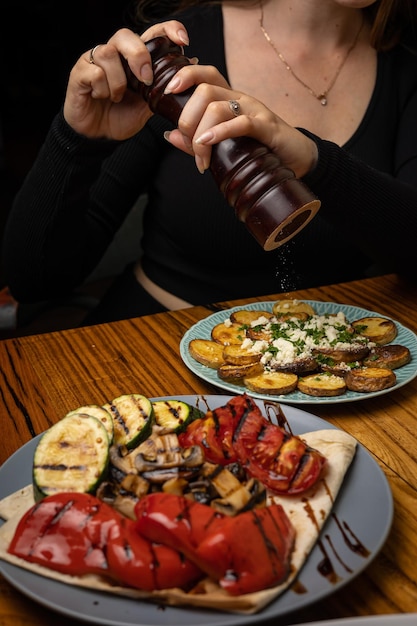 appetizing grilled vegetables on plates on a dark wooden table