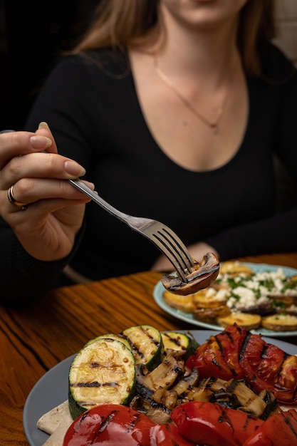 appetizing grilled vegetables on plates on a dark wooden table