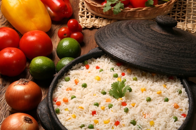 Appetizing healthy rice with vegetables in white plate on a wooden table. rice colored