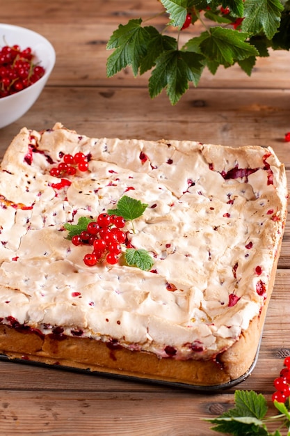 Appetizing homemade berry pie Pie with red currants and sour cream on wooden table