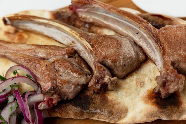 Appetizing lamb ribs on pita bread Traditional dish of Caucasian cuisine Closeup