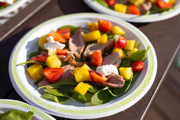 appetizing light salads with strawberries in plates on the table