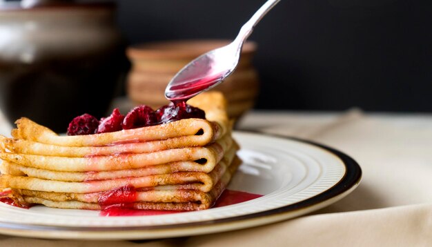 Appetizing pancakes on a plate sprinkled with raspberry jam on top Image with selective focus