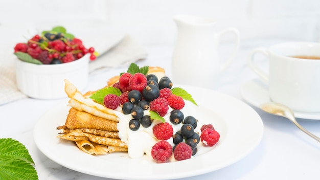 Appetizing pancakes with berries on a light background