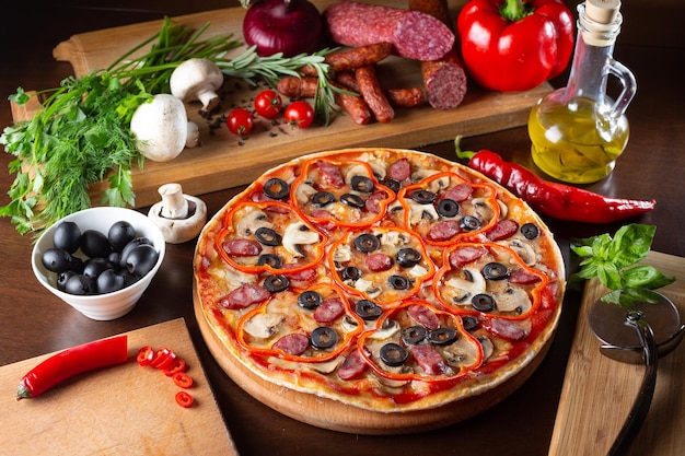 Appetizing pizza on a dark table with ingredients