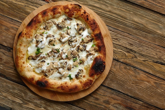 Appetizing pizza with mushrooms on a wooden tray