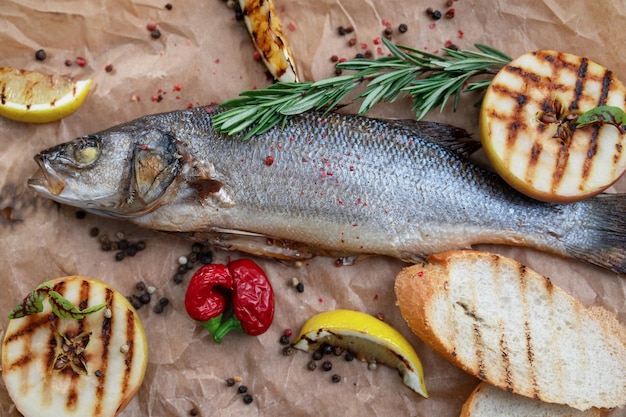 Appetizing sibas fish with greens and vegetables on a wooden background