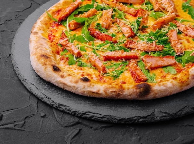 Appetizing smoked salmon pizza on dark background