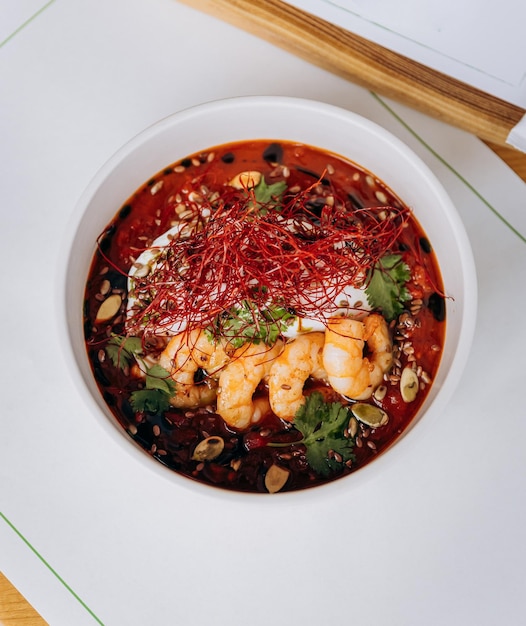 Appetizing thai food of pumpkin porridge with shrimps served with greens and seeds in restaurant