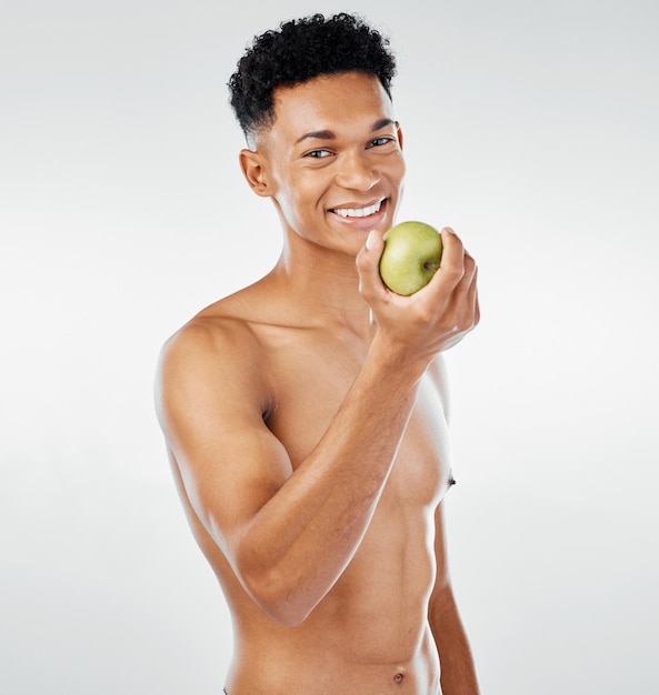 Apple body and diet with a model black man posing in studio on a gray background for healthy eating Portrait fruit and health with a handsome young male inside to promote a natural or green food